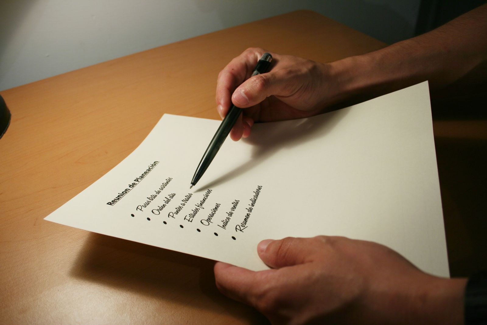 A hand marking up a printed document with a pen